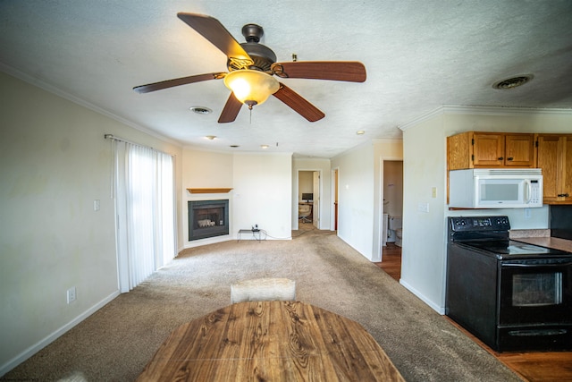 kitchen with black electric range oven, crown molding, carpet flooring, ceiling fan, and a textured ceiling