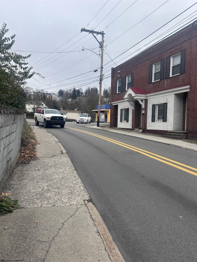 view of road featuring curbs, street lighting, and sidewalks