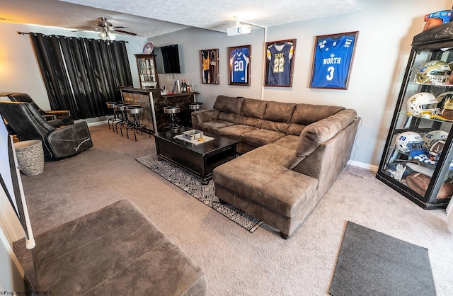 living room with carpet flooring, a textured ceiling, indoor bar, and ceiling fan