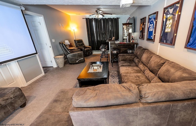 living room with bar area, ceiling fan, carpet, and a textured ceiling