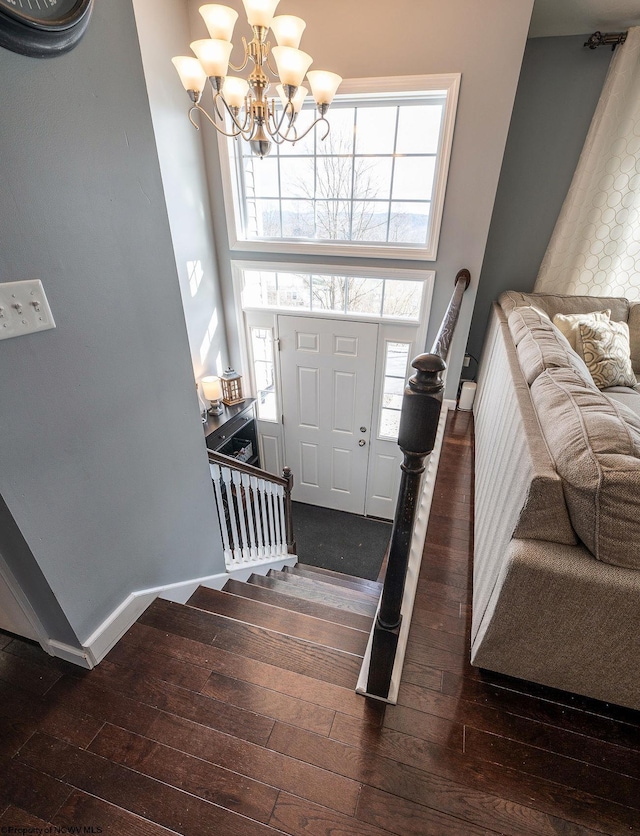 entryway featuring a notable chandelier, plenty of natural light, and dark wood-type flooring