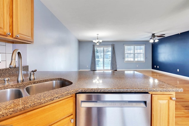 kitchen featuring ceiling fan with notable chandelier, light hardwood / wood-style flooring, stainless steel dishwasher, and sink