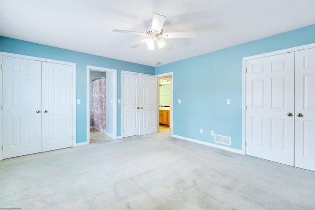 unfurnished bedroom with ensuite bathroom, ceiling fan, and light carpet