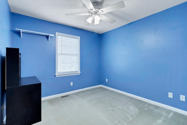 carpeted spare room with ceiling fan