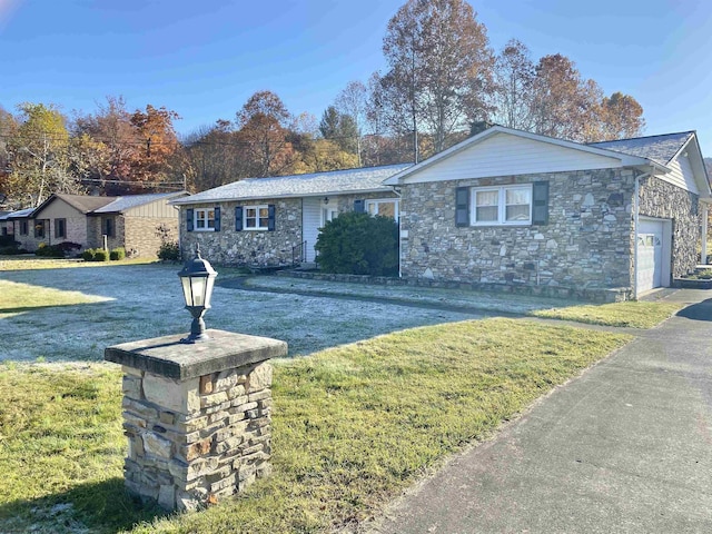 ranch-style home featuring a garage and a front lawn