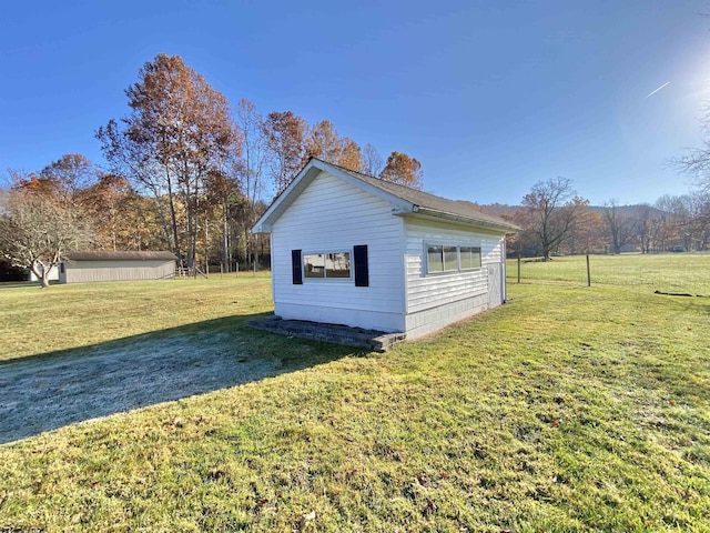 view of side of home featuring an outbuilding and a lawn