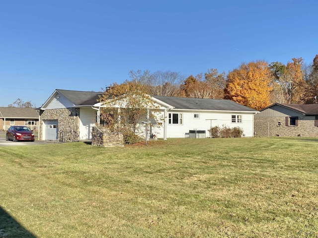 view of front facade featuring a front yard, a garage, and central AC unit