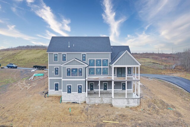 back of house featuring a shingled roof, a patio area, and board and batten siding