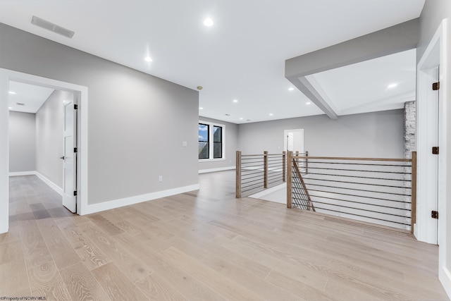 spare room with light wood-type flooring, visible vents, baseboards, and recessed lighting