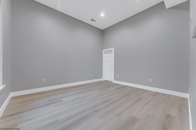 empty room with light wood-style flooring, visible vents, baseboards, and recessed lighting