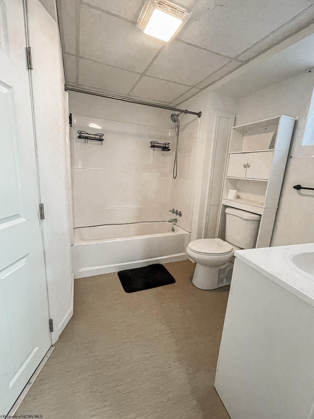 full bathroom with toilet, a drop ceiling, vanity, and tiled shower / bath