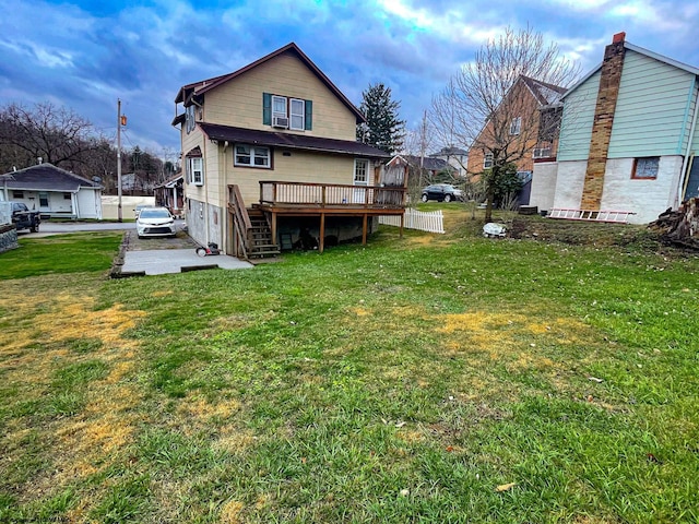 rear view of house with a wooden deck and a yard