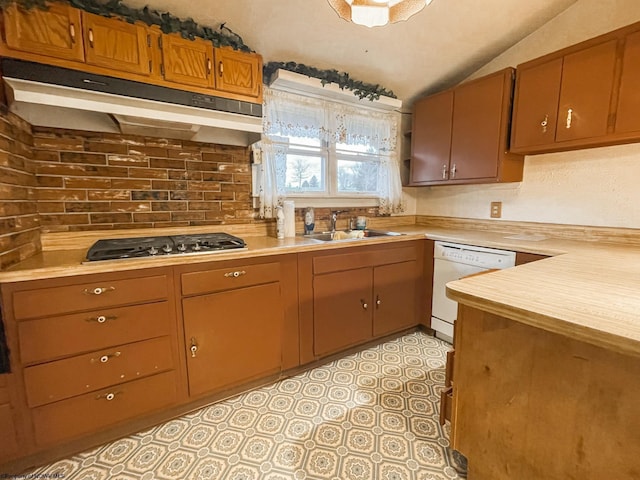 kitchen featuring white dishwasher, lofted ceiling, sink, and stainless steel gas cooktop