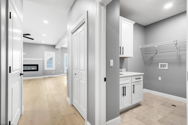 clothes washing area featuring light hardwood / wood-style floors and hookup for a washing machine