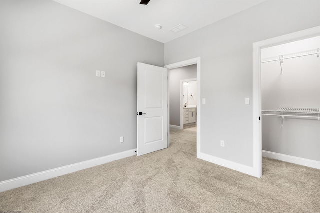 unfurnished bedroom featuring light carpet, ceiling fan, and a closet