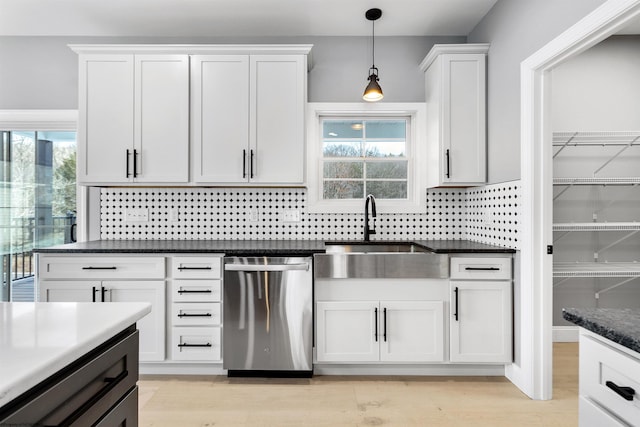 kitchen with sink, dishwasher, white cabinetry, hanging light fixtures, and plenty of natural light