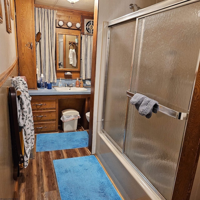 full bathroom with shower / bath combination with glass door, vanity, wood-type flooring, and toilet