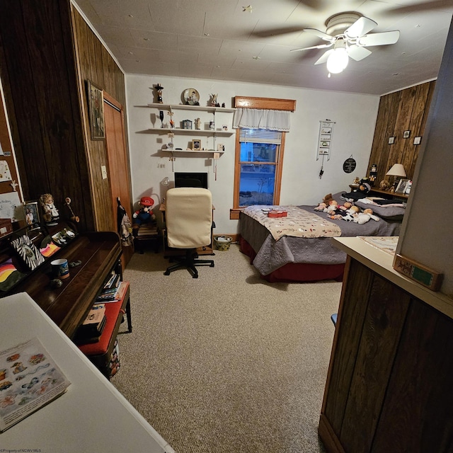 carpeted bedroom with ceiling fan and wood walls