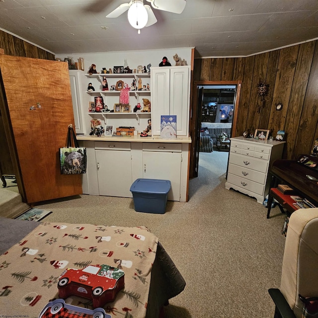 bedroom with light colored carpet, ceiling fan, and wood walls