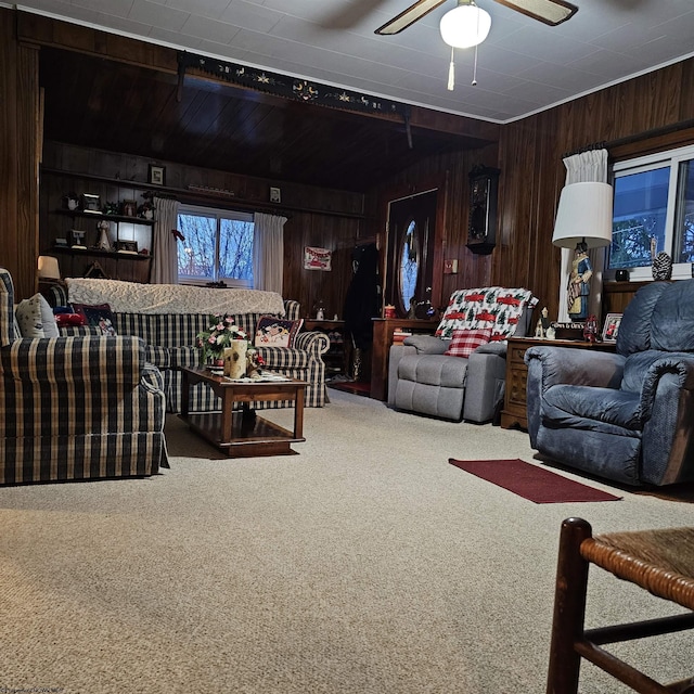 living room featuring carpet, ceiling fan, and wood walls