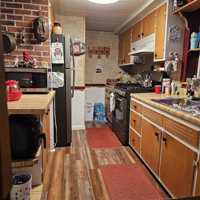 kitchen with stainless steel appliances, light hardwood / wood-style flooring, and sink