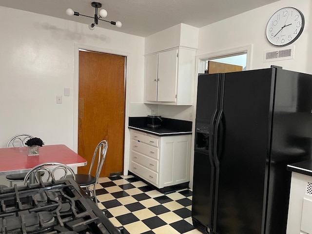 kitchen with white cabinets and black fridge with ice dispenser