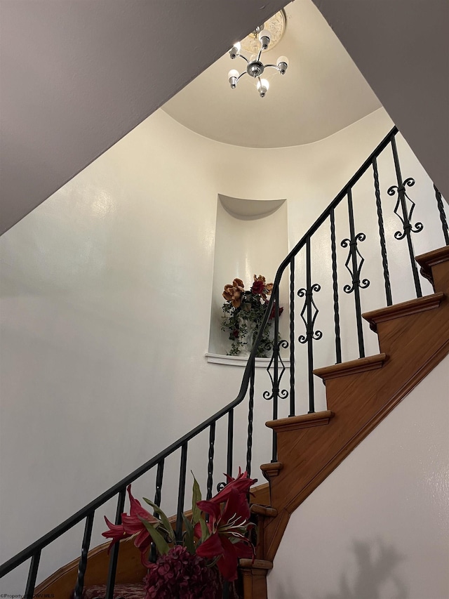 stairway with a notable chandelier