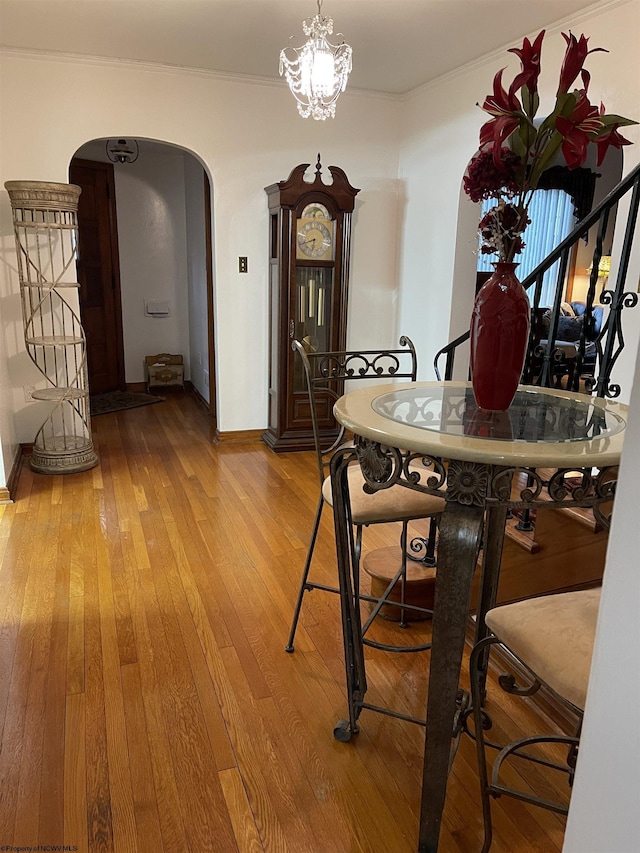 dining room with crown molding, hardwood / wood-style floors, and a notable chandelier