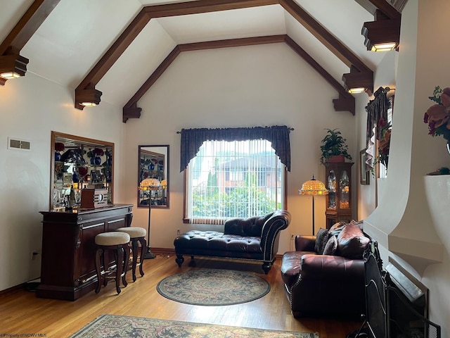 living room with beam ceiling, light hardwood / wood-style floors, and high vaulted ceiling