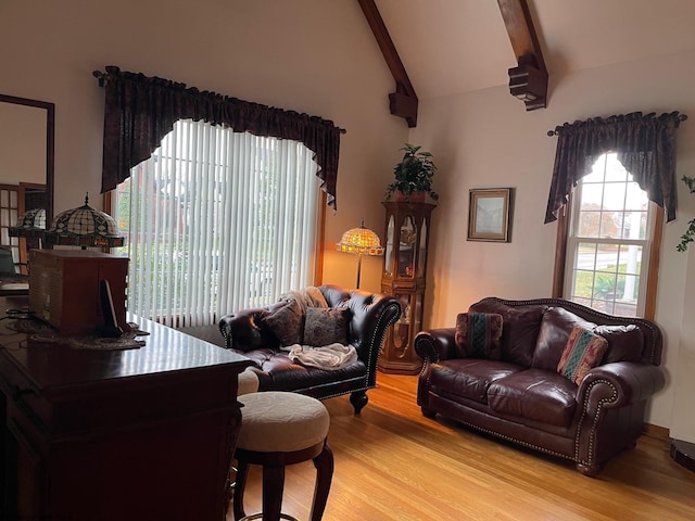 living room with vaulted ceiling with beams and light wood-type flooring