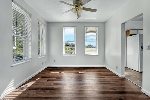 spare room with ceiling fan, dark wood-type flooring, and a textured ceiling