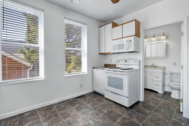 kitchen featuring white cabinetry, sink, and white appliances