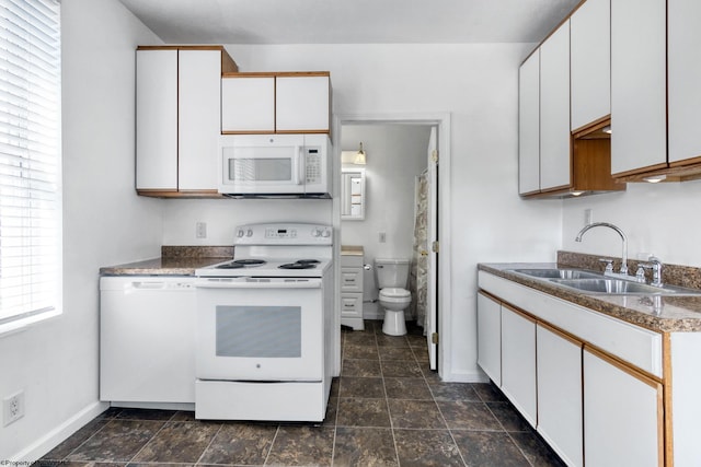 kitchen with white cabinetry, sink, and white appliances