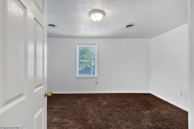 carpeted spare room with a textured ceiling