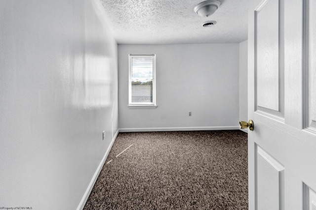 carpeted empty room with a textured ceiling