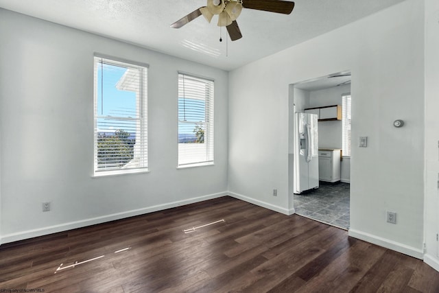 empty room with ceiling fan, dark hardwood / wood-style flooring, and a textured ceiling