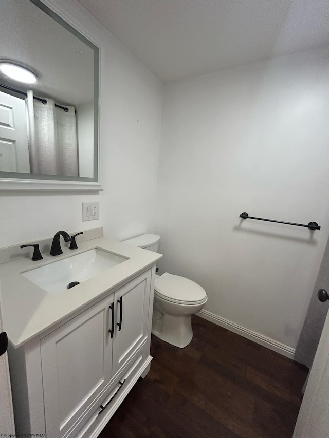 bathroom featuring hardwood / wood-style floors, vanity, and toilet