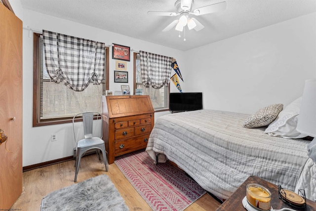 bedroom with a textured ceiling, light hardwood / wood-style flooring, and ceiling fan