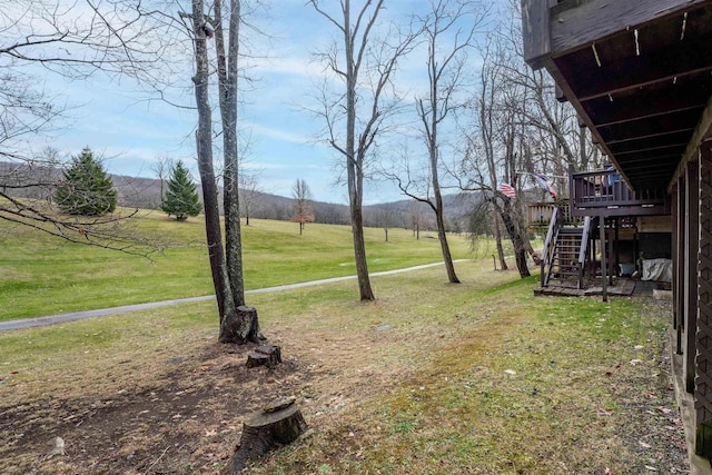 view of yard with a rural view and a deck with mountain view