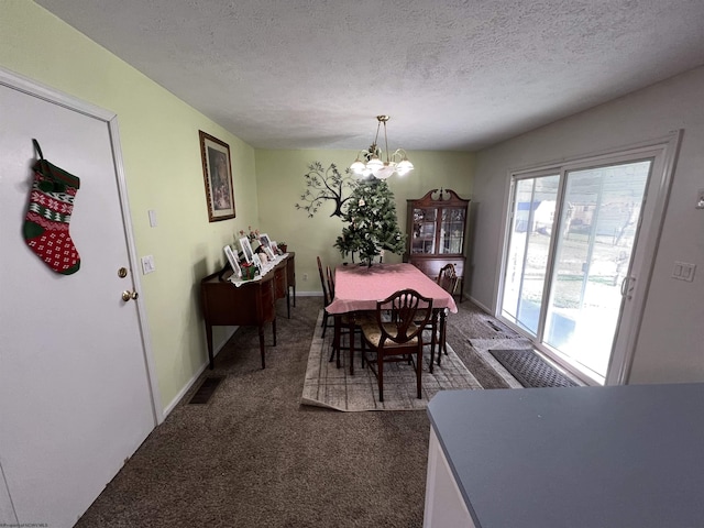 dining room featuring dark colored carpet, a textured ceiling, and a notable chandelier