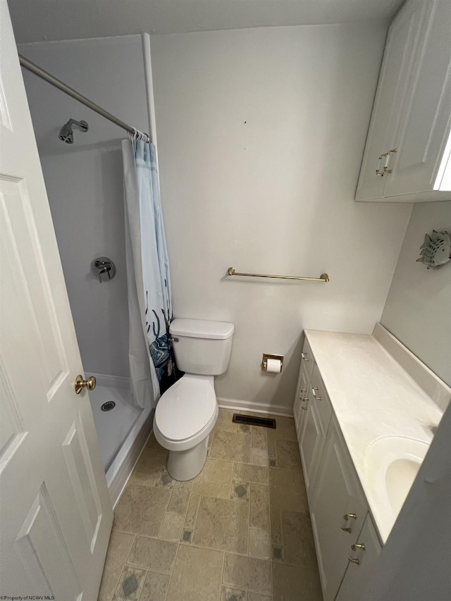 bathroom with toilet, vanity, and a shower with shower curtain