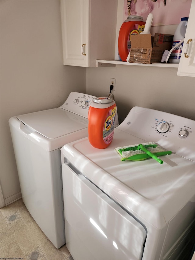 laundry area featuring washer and dryer and cabinets