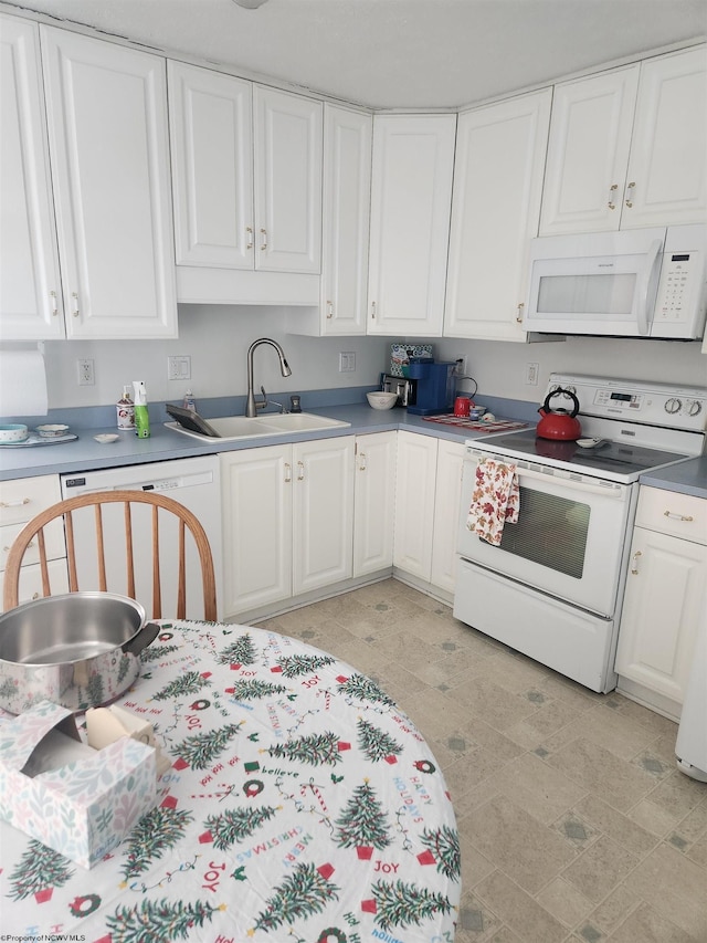 kitchen featuring white appliances, white cabinetry, and sink