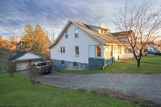 view of side of home featuring a lawn, an outbuilding, and a garage