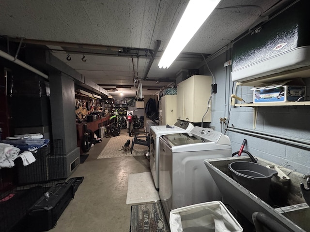 washroom featuring a workshop area, washer and clothes dryer, cabinets, and sink