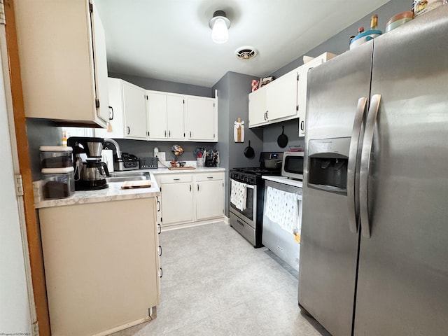 kitchen with white cabinets, sink, and appliances with stainless steel finishes