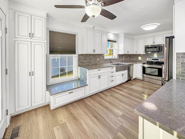 kitchen featuring white cabinets, light hardwood / wood-style floors, sink, and appliances with stainless steel finishes