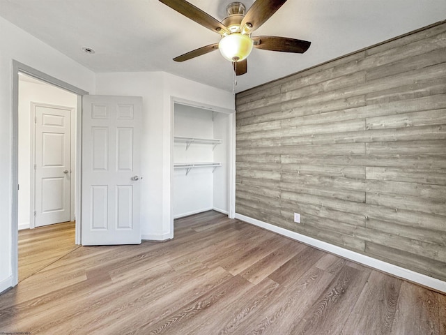 unfurnished bedroom with ceiling fan, a closet, and light hardwood / wood-style floors