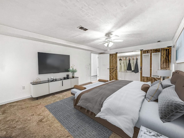 carpeted bedroom with a textured ceiling and ceiling fan