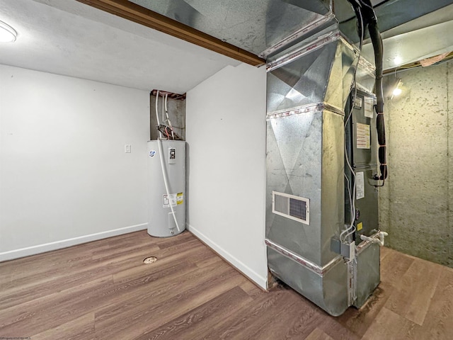 utility room with heating unit and water heater